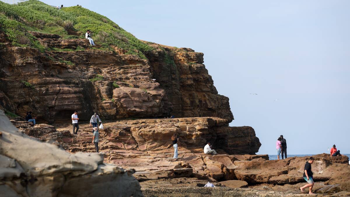 People walking near the headland at City Beach in Wollongong. Picture by Adam McLean
