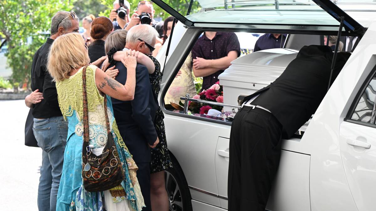 Victor White (centre) husband of Vyleen White is seen being hugged by mourners at the funeral service for his wife. Picture AAP Image