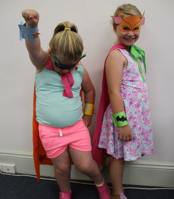 Lucy Contre, 6, and Phoebe Olivia, 6, strike a pose and show off their superhero creations, made at Bowral Library during the hero and villain themed school holiday activities.