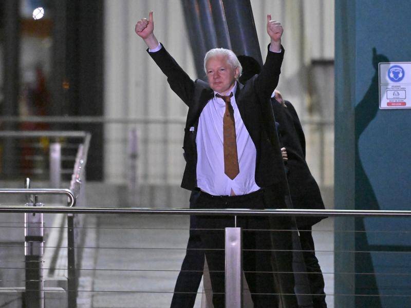 Julian Assange raises his arms and gives the thumbs up after landing in Canberra a free man. (Mick Tsikas/AAP PHOTOS)