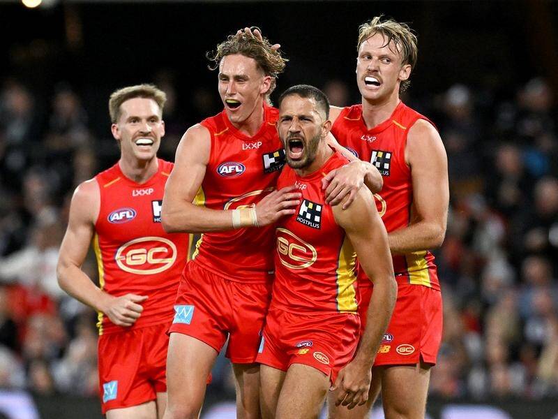 Gold Coast are celebrating after holding off defending premiers Collingwood for an 11-point win. (Dave Hunt/AAP PHOTOS)